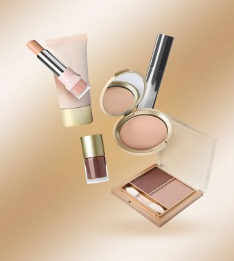 Bej renkli arkaplana karşı havada farklı makyaj kozmetikleri