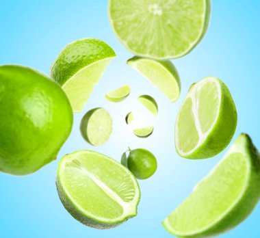 Açık mavi arka planda taze limonlar havada dönüyor.