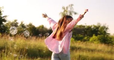 Özgürlüğü hissetmek. Mutlu genç bir kadın doğanın tadını çıkarıyor. Kamera sağa hareket ediyor