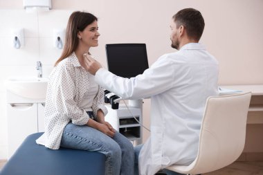 Klinikte kadının tiroid bezini ultrason taraması yapan sonograf.