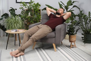 Uyum. Evdeki rahat koltukta dinlenen adam.