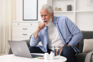 Üst düzey bir adam evde bilgisayarla doktorla görüşüyor.