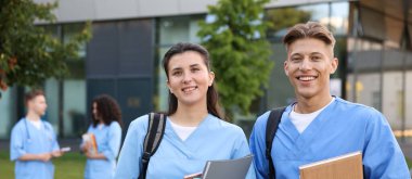 Dışarıda defterleri olan tıp öğrencileri, seçici bir odak noktası.