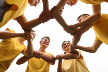 Takım oluşturma. Dışarıda el ele tutuşan bir grup mutlu insan.