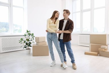 Evde dans eden mutlu genç çift ve karton kutular. Taşınma günü