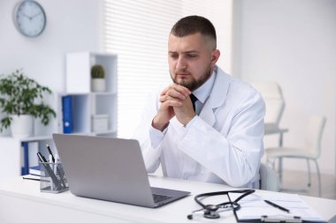 Klinikte bilgisayarla online danışmanlık yapan bir doktor