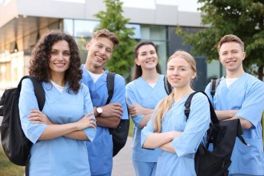 Sırt çantalı bir grup tıp öğrencisi dışarıda.