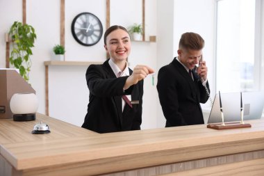 Otelin resepsiyonunda çalışan gülümseyen resepsiyonistler