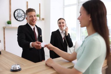 Otel resepsiyonunda resepsiyonist ve müşteri