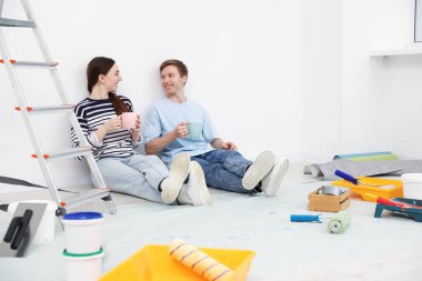 Evde tadilat sırasında kahve içen çift.