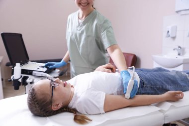 Sonograf, klinikte kızın kolunun ultrason muayenesi yapıyor.