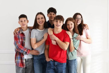 Bir grup mutlu genç evde birlikte poz veriyor.