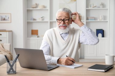 Üst düzey adam içeride masa başında öğrenirken not alıyor. Kendi kendine çalışma.