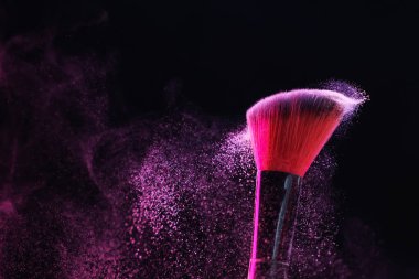 Siyah arka planda pembe göz farlı makyaj fırçası, yakın plan.