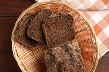 Hasır sepetin içinde taze çavdar ekmeği, ahşap masanın üstünde.