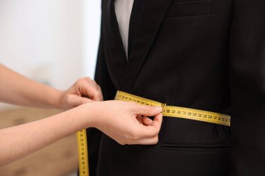 Atölyedeki adama terzi ceketi, yakın plan.