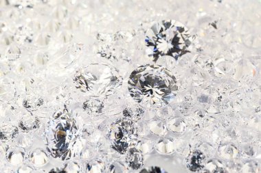 Işıklı arka planda pek çok parlak elmas, yakın plan