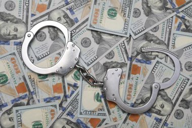 Yozlaşma. Dolar banknotlarında kelepçe, üst manzara.