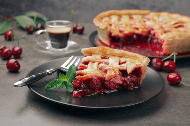 Gri masadaki lezzetli vişneli turta ve böğürtlen, yakın plan.