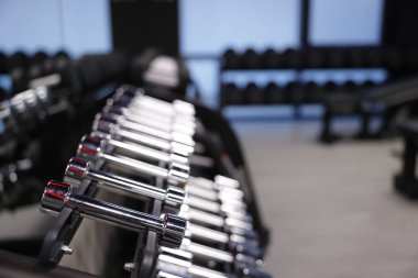 Spor salonunda birçok metal dambıl var, yakın plan. Metin için boşluk