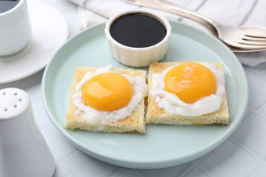 Lezzetli kaya tostları, yarım haşlanmış yumurtalarla beyaz fayanslı masada servis edilir, yakın plan. Geleneksel Asya kahvaltısı