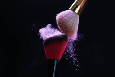 Siyah arka planda mor göz farlı makyaj fırçaları, yakın plan