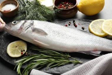 Gri masadaki baharatlı taze çiğ deniz kabuğu, yakın plan. Balık ve deniz ürünleri lezzetleri