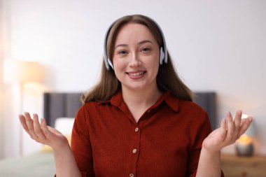 Kulaklık takan bir kadın evde doktorla görüşüyor.