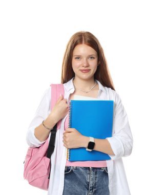 Sırt çantası ve beyaz arka planda defterleri olan tatlı bir genç kız.