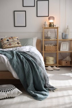 Yumuşak çarşafları olan rahat bir yatak ve şık bir odası olan bir raf. Ev tekstili