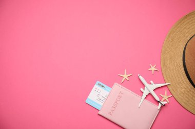 Uçak modeli, pasaport, uçuş bileti, deniz yıldızları ve pembe arka planda şapka, düz konum. Metin için boşluk