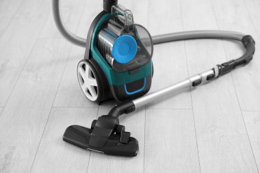 Tahta zeminde bir elektrikli süpürge. Ev aletleri