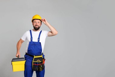 Gri arkaplanda alet kutusu olan profesyonel tamirci, metin için boşluk