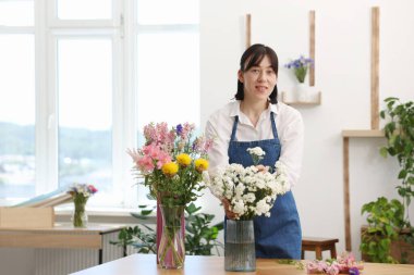 İçerideki masada güzel bir buket çiçekle çiçekçi.