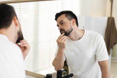 Banyoda aynaya bakmadan önce yakışıklı bir adam.