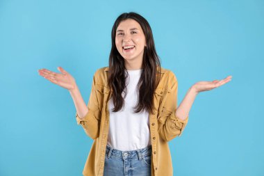 Açık mavi arka planda şaşırmış bir kadının portresi