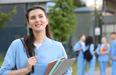 Sırt çantalı ve defterli tıp öğrencisi, seçici bir odak noktası var.