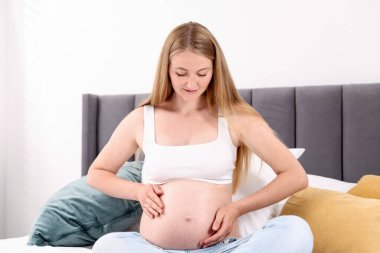 Evde yatakta güzel hamile kadın