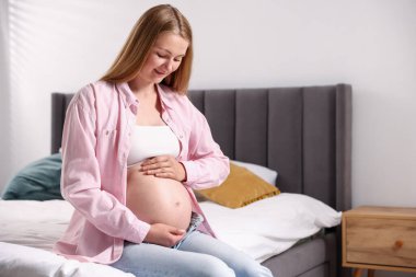 Evdeki yatakta güzel hamile bir kadın. Metin için boşluk