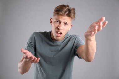 Gri arka planda kafası karışmış bir adamın portresi