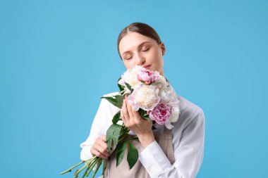 Açık mavi arka planda güzel şakayık demeti olan bir çiçekçi.