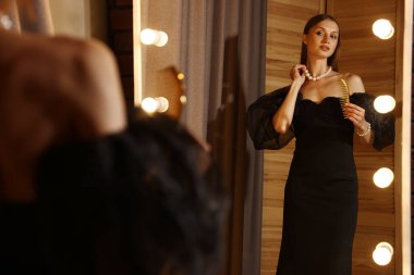 Taraklı kadın içeride aynanın yanında hazırlanıyor.