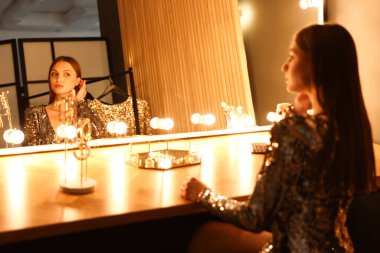 Güzel bir kadın tuvalet masasında hazırlanıyor.