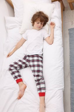 Evdeki yatakta uyuyan şirin küçük çocuk, üst manzara.