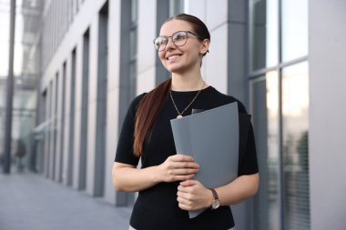 Ofis binasının yanındaki klasörde başarılı bir iş kadını