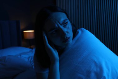 Evde yatağında uykusuzluk çeken, yastıklı hayal kırıklığına uğramış bir kadın.