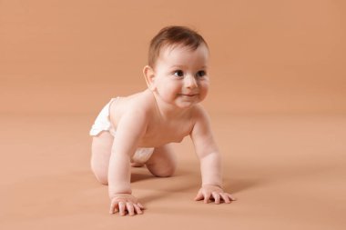 Bej arka planda emekleyen şirin bir bebek.