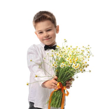 Şirin küçük çocuk beyaz arka planda bir buket güzel papatya çiçeği veriyor.