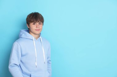 Açık mavi arka planda yakışıklı bir gencin portresi. Metin için boşluk