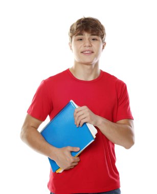 Beyaz arka planda defterleri olan mutlu genç çocuk.